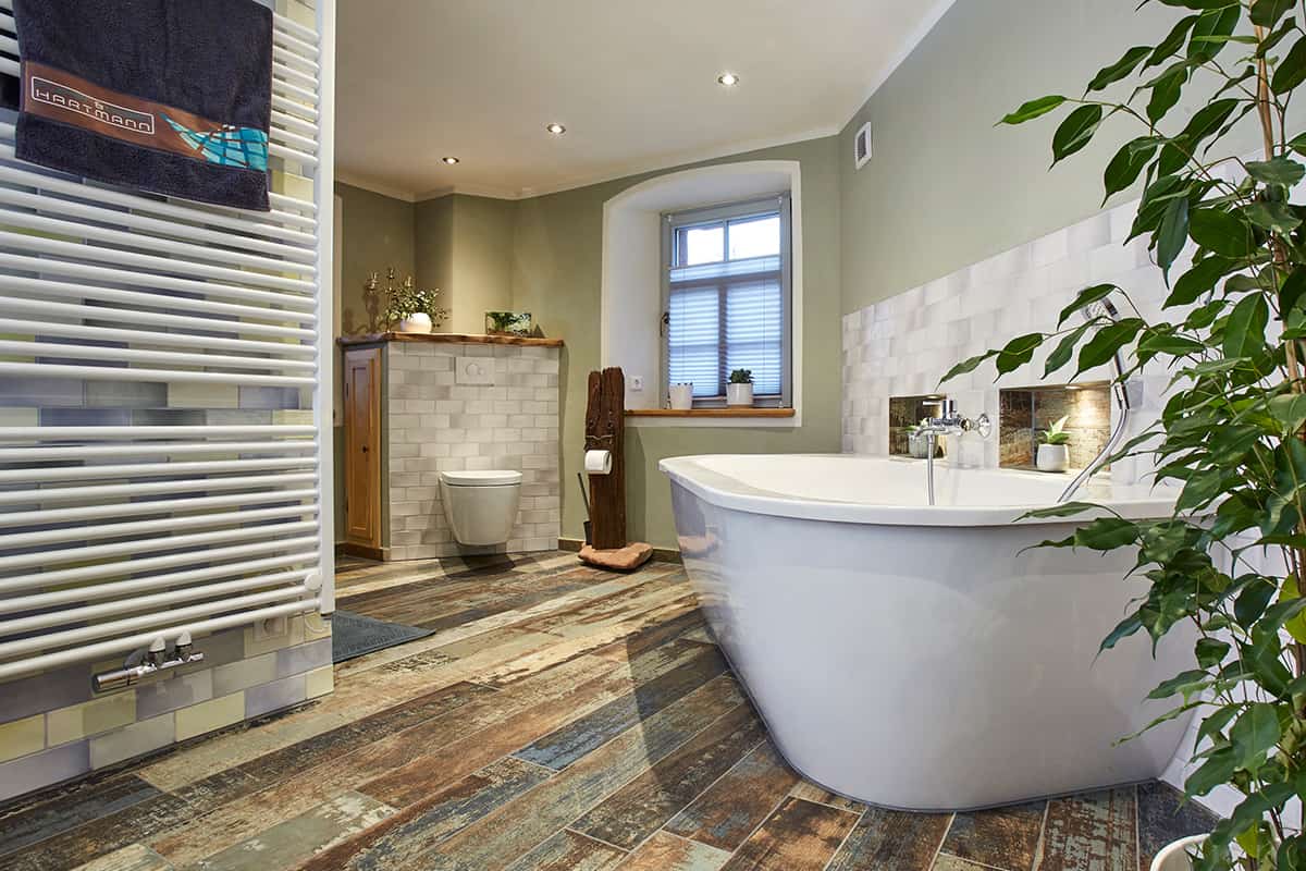 Bad mit Charakter und Farbe Blick auf Badewanne und WC-Bereich mit Handtuchheizung im Vordergrund